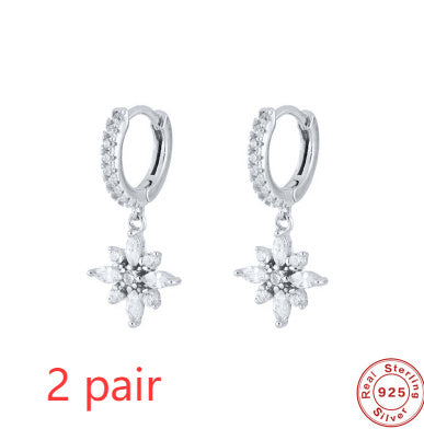 Pair of silver hoop earrings with star-shaped dangling elements on a white background, featuring 'Real Sterling Silver' stamp.