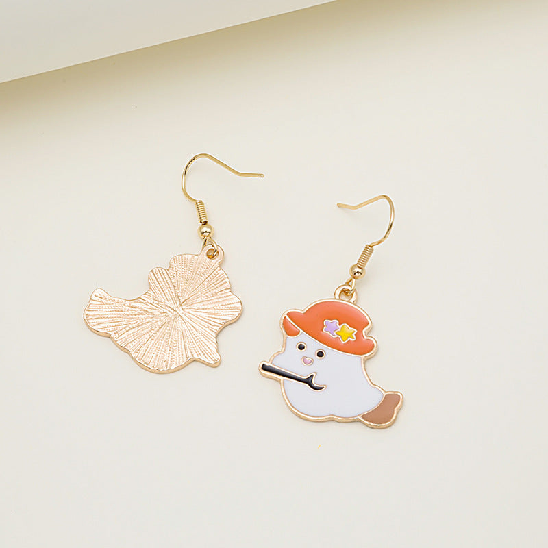 Ghostly unique gold earrings on a light beige background