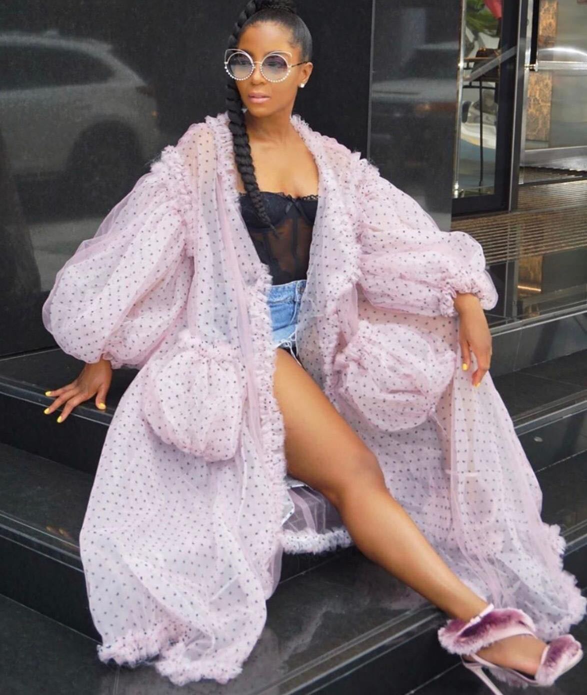 Women wearing a pink sheer cover up sitting on steps.
