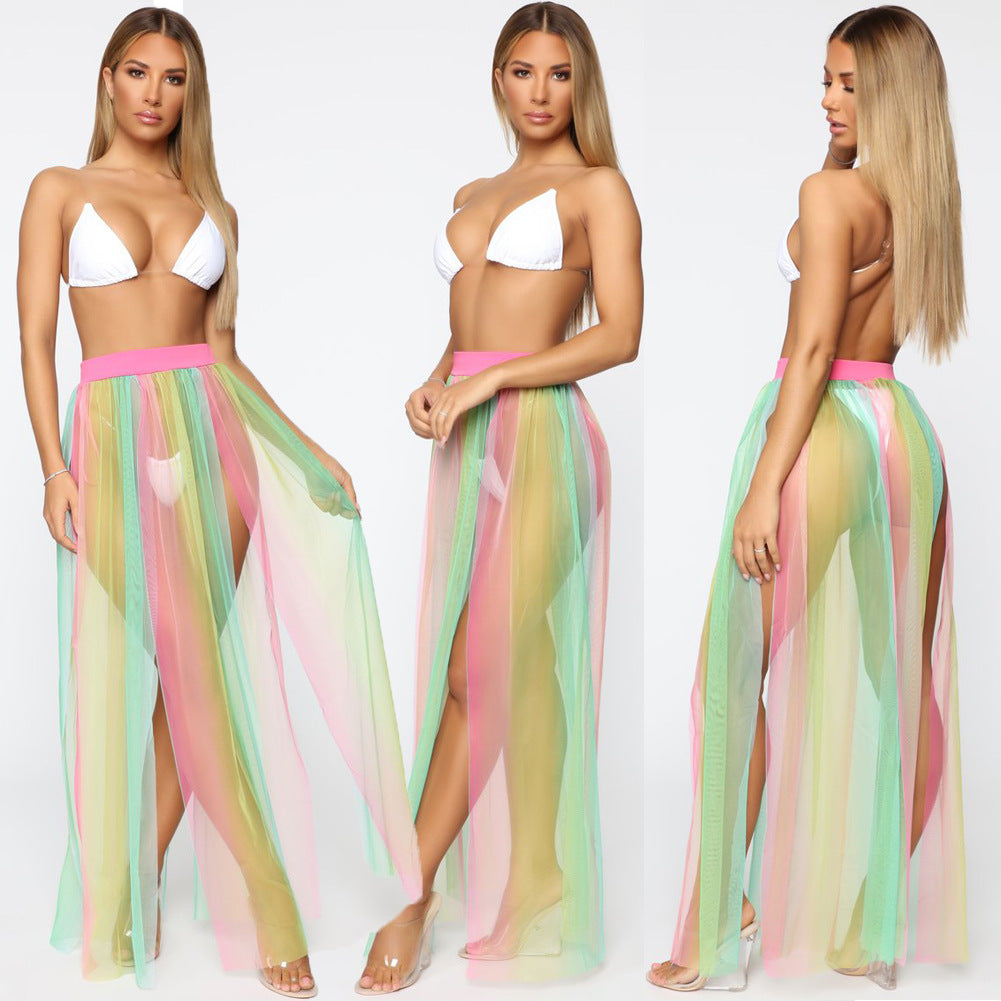 Woman wearing a white bikini top and colorful sheer skirt on a white background