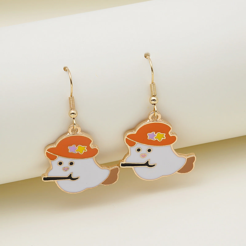 Pair of gold earrings with cartoon ghost character design on a light background