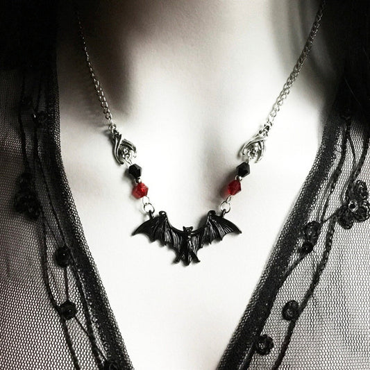 Necklace with bat-shaped pendants on a mannequin wearing black lace