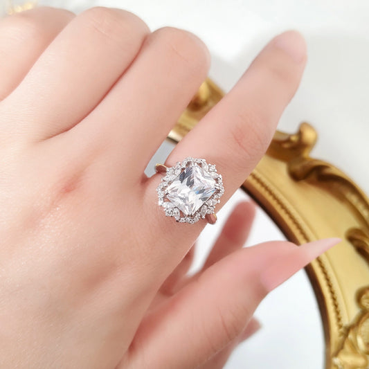Silver ring with a 810 Zircon stone on a gold decorative background